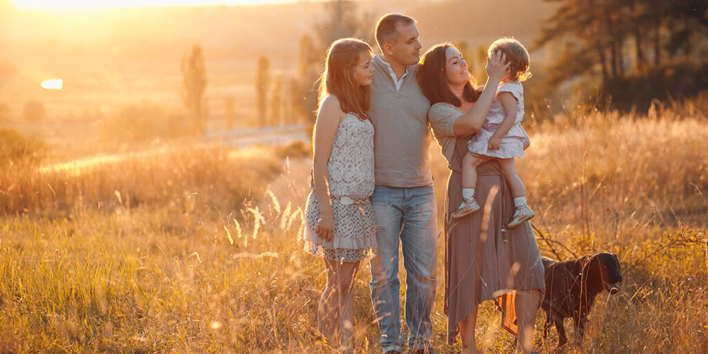 imagen de una familia unida en el campo al aterdecer